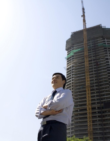 Engineer looking up at a high-rise under construction