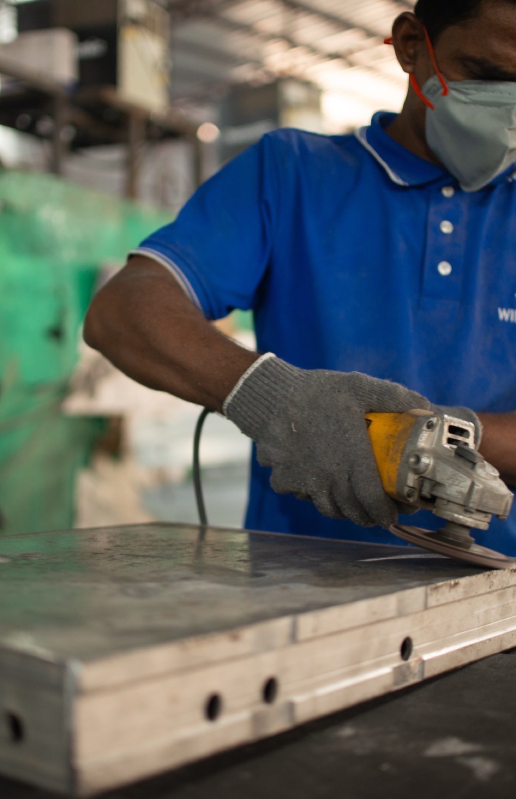 A workshop fabricator finishing a panel edge