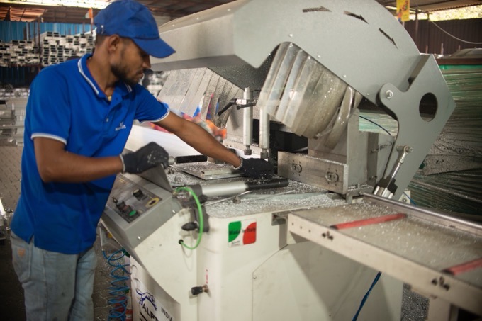 A machine operator cutting aluminium formwork panels in the fabrication workshop